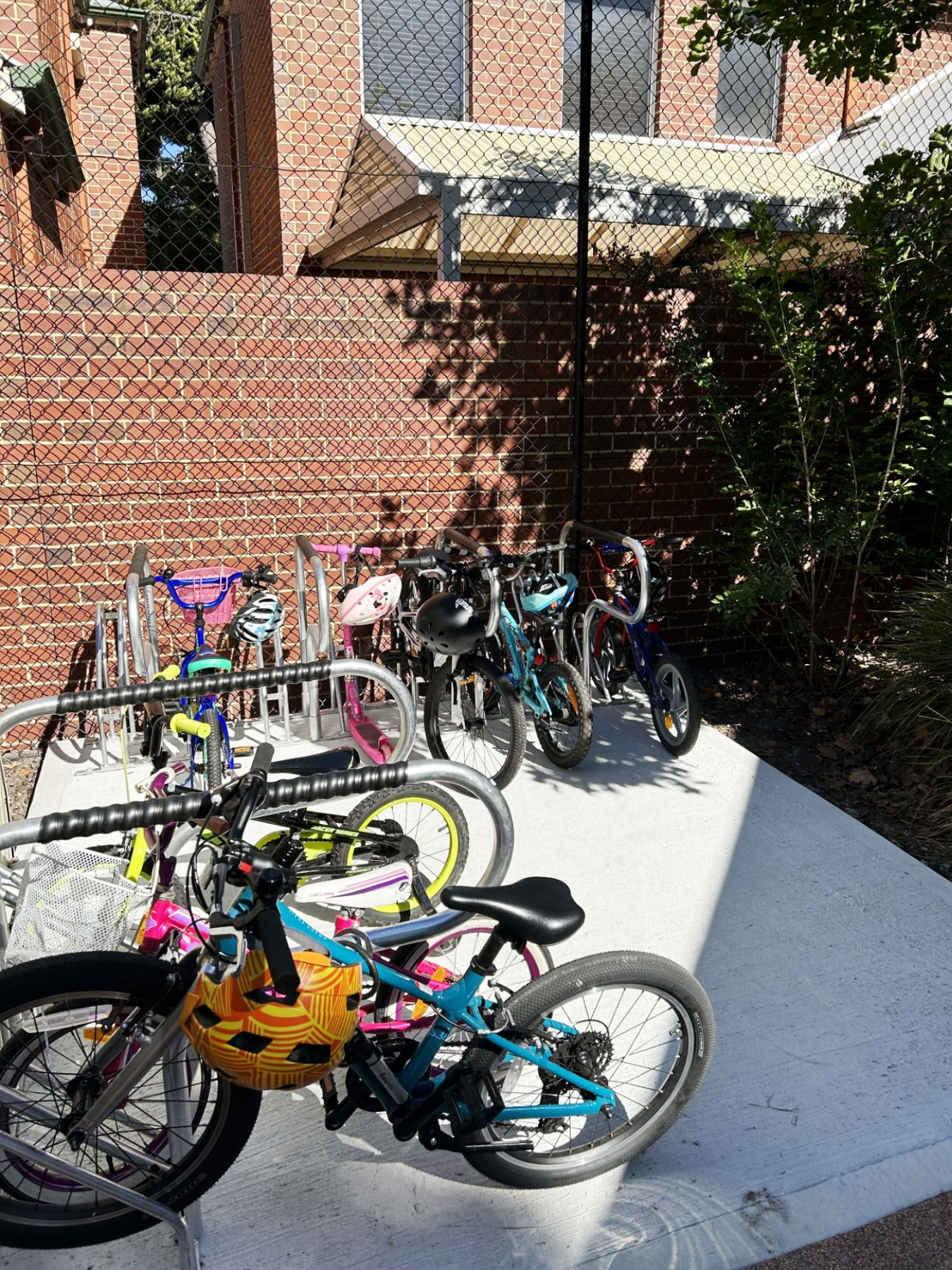 Bicycles and scooters parked in two bike racks.
