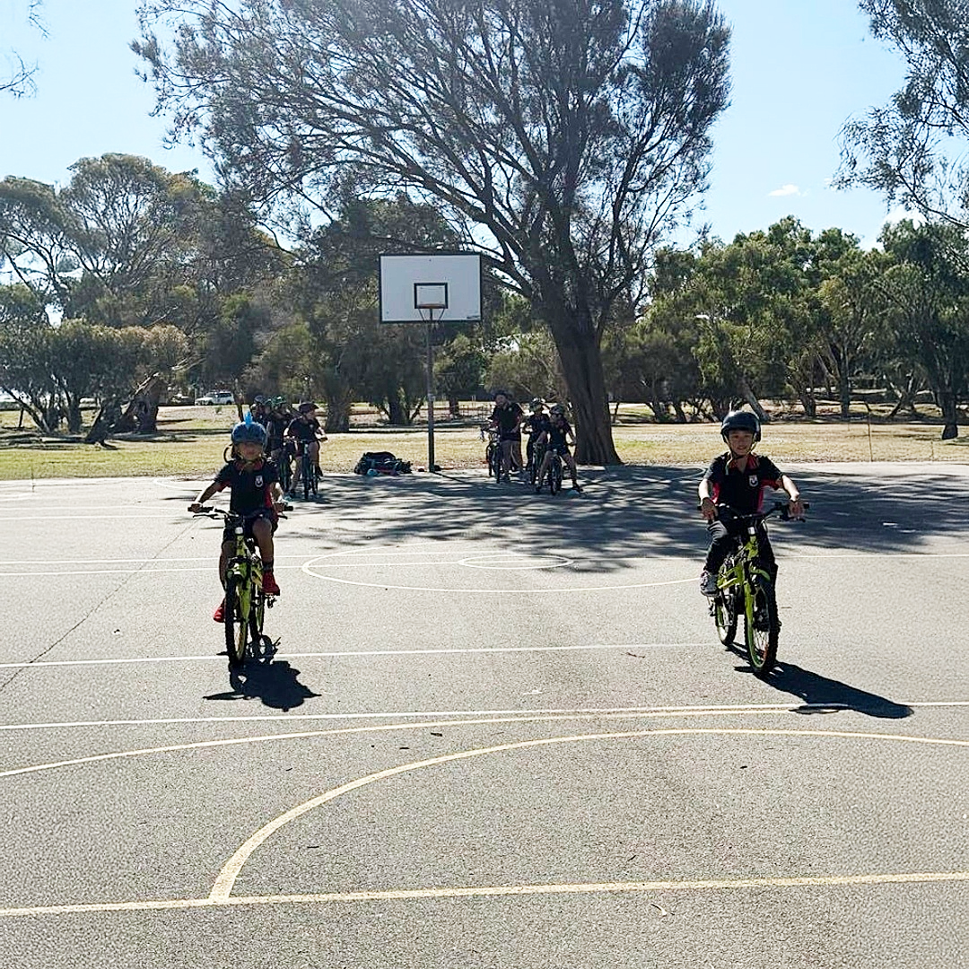 A group of students riding bikes on a basketball court