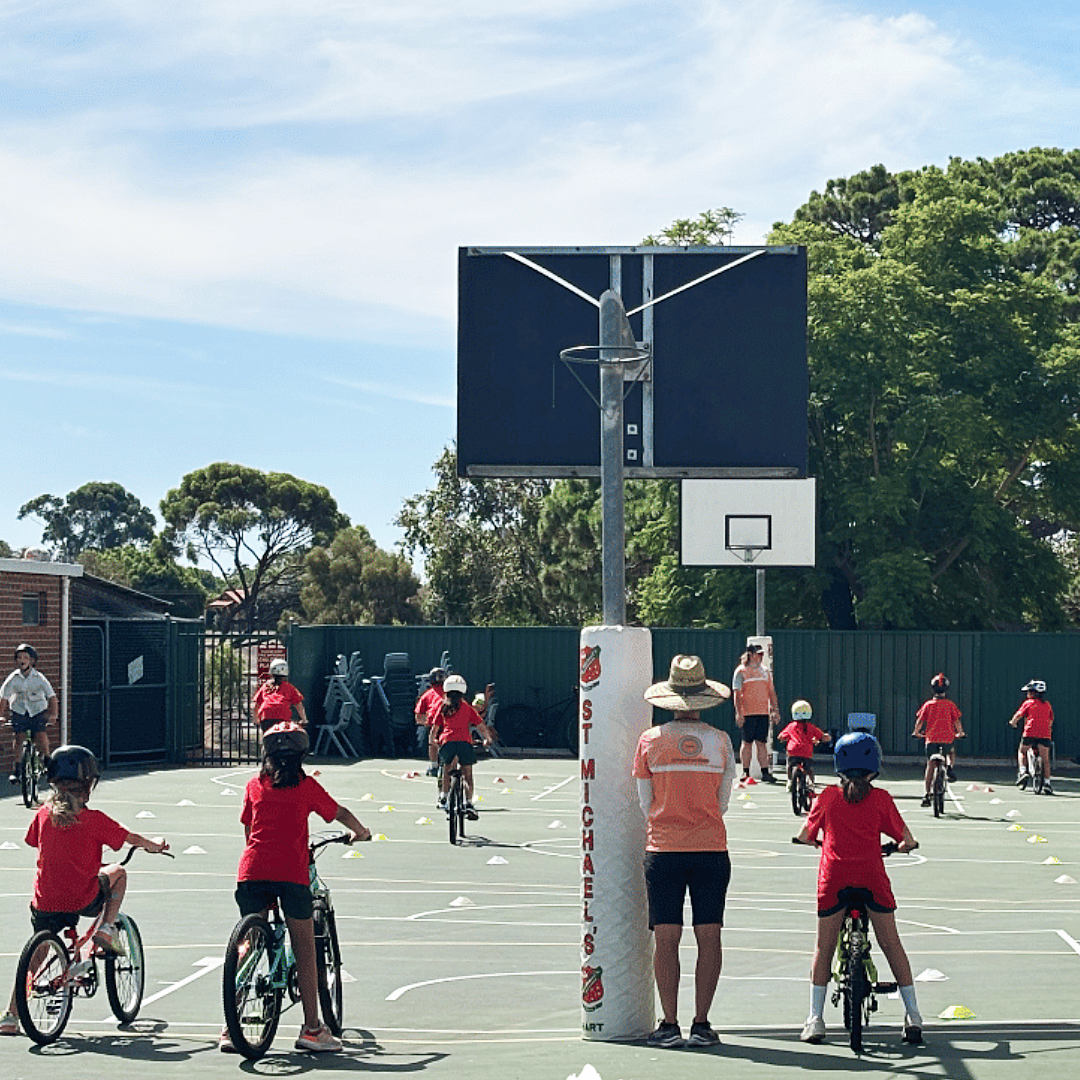 A group of students taking part in bike education lessons on a basketball court